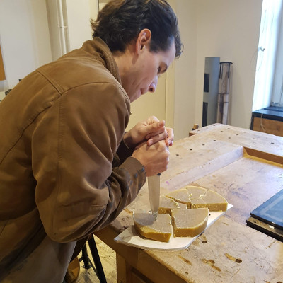 Nicolas stabbing the wax with a giant knife